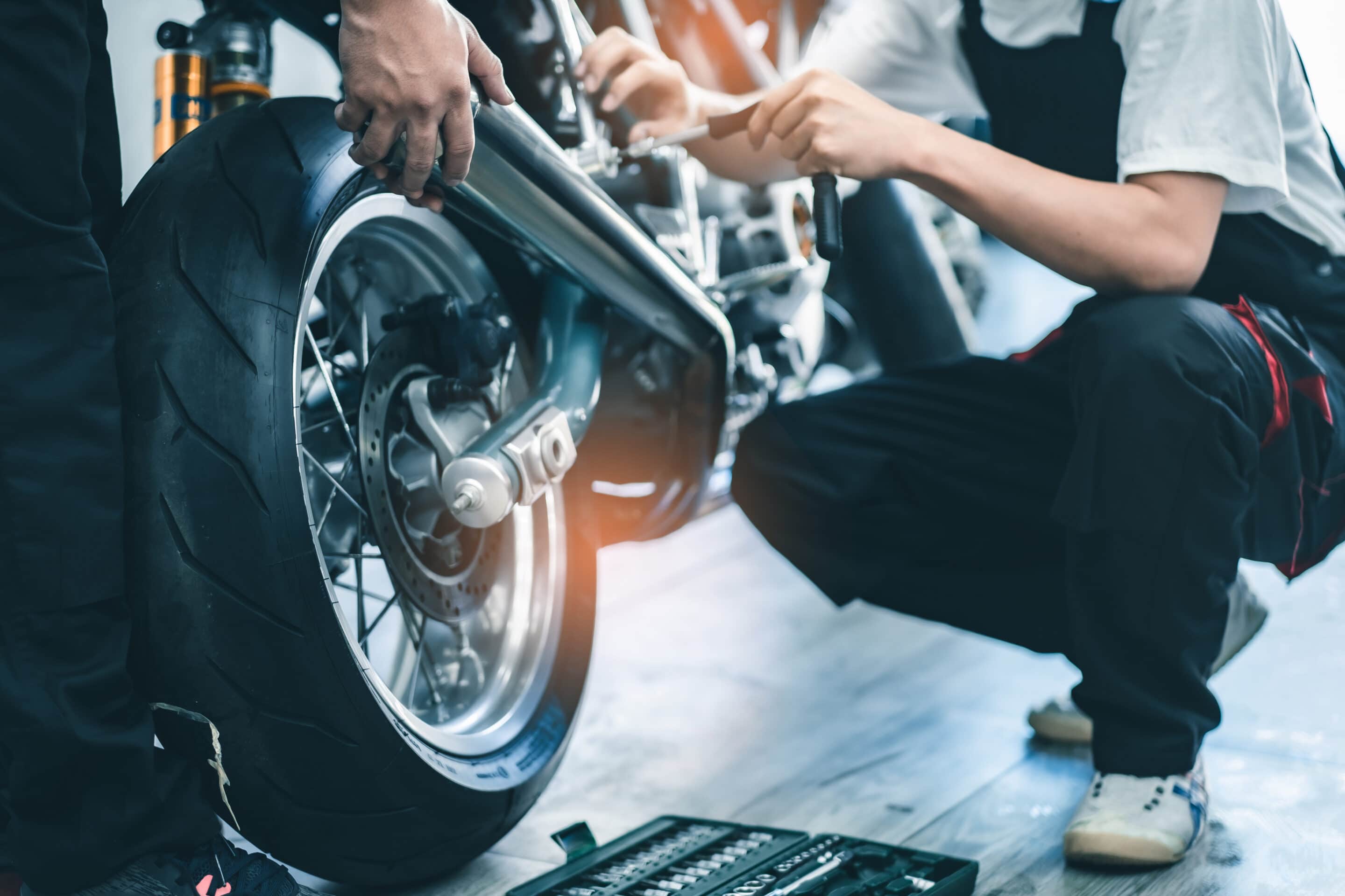 bike repair. young man repairing motobike in garage.mechanic fixing motocycle engine.serious young man repairing his motorcycle in bike repair shop.